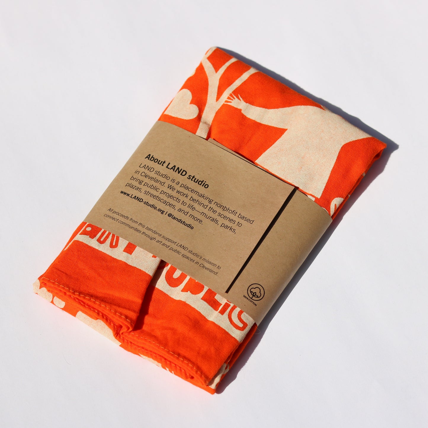 Folded fabric with orange and beige design on a white background